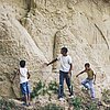 junger Mann und zwei Kinder vor einer Felswand