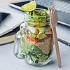Foto: Salat in einem Glas, mit Avocado und Quinoa, auf einem Schreibtisch stehend