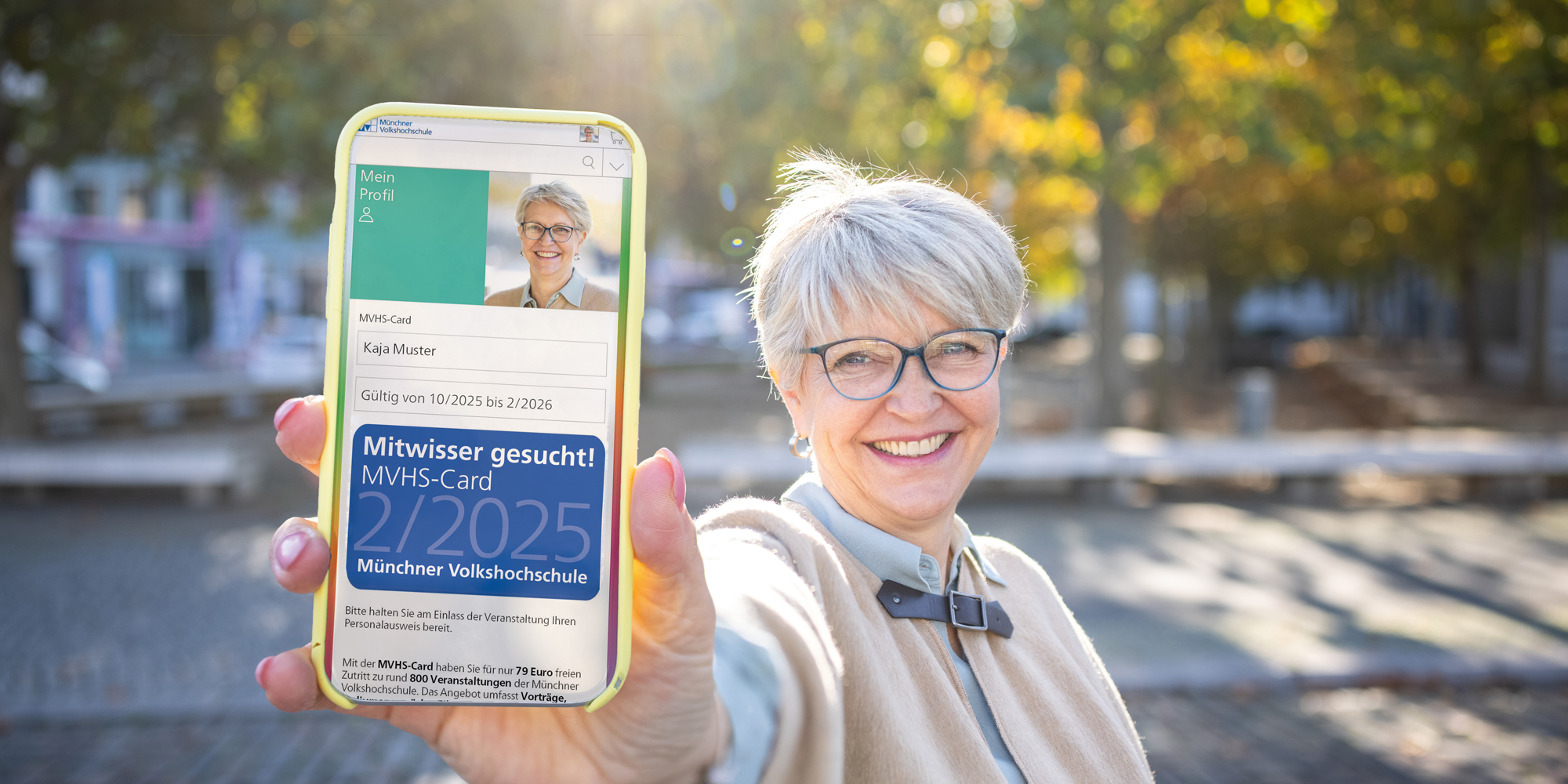 ältere Frau mit MVHS-Card 2/2025 auf dem Smartphone